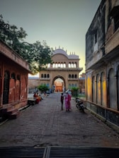 a couple of people walking down a street between buildings