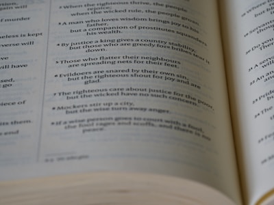 A close-up photo of an open vintage book with handwritten poetry on its pages.