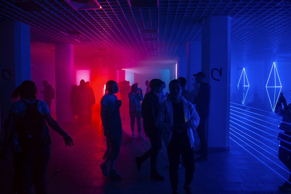 a group of people walking through a room with bright lights