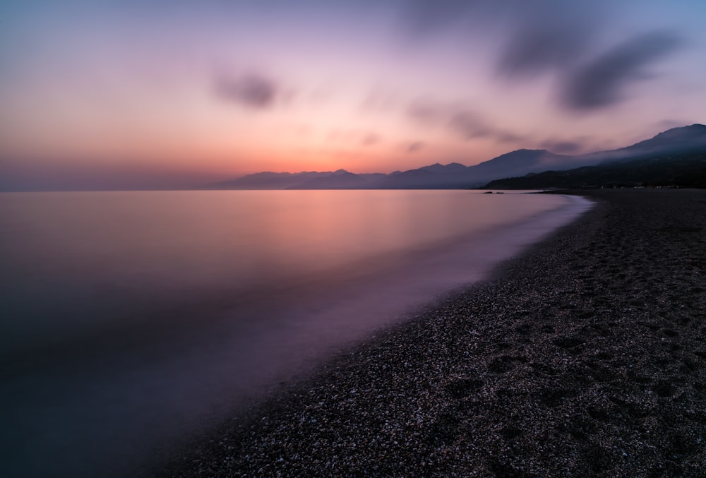 a body of water with mountains in the background