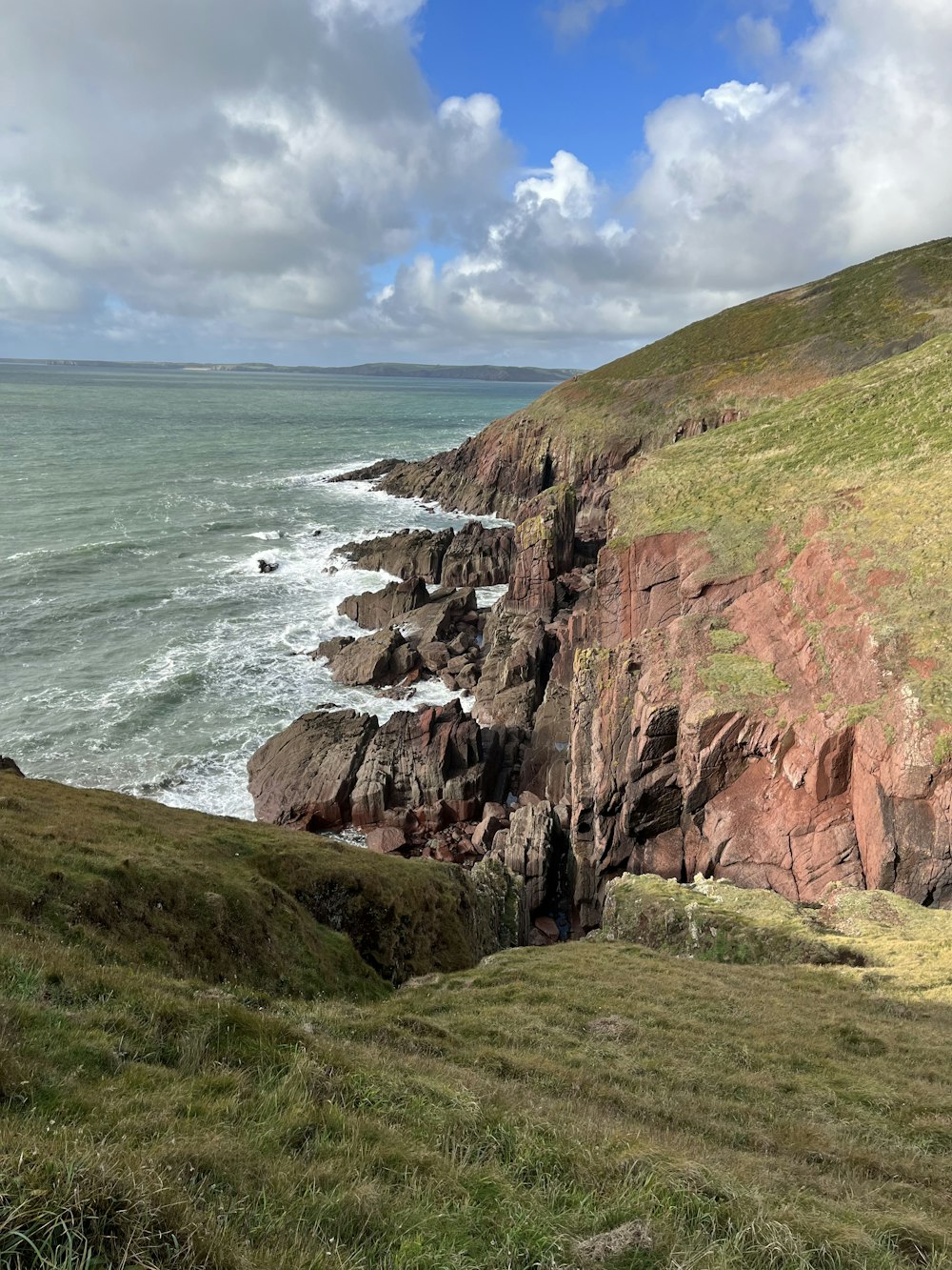 a cliff side with a body of water below