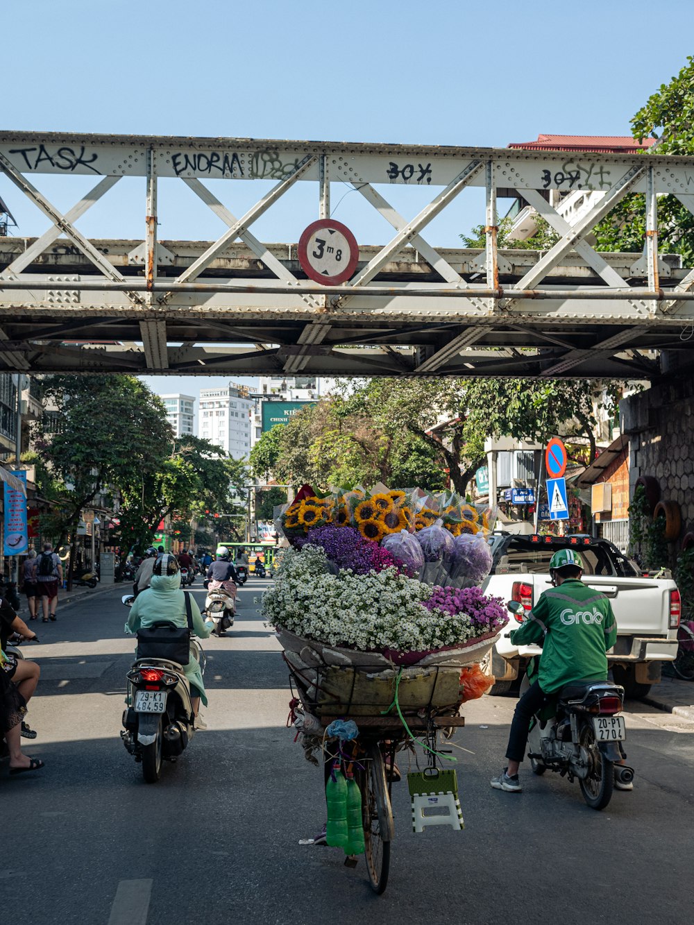 a person riding a motorcycle with a cart full of flowers