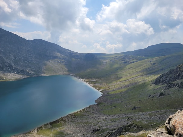 A serene landscape featuring mountains and a calm lake at sunrise.