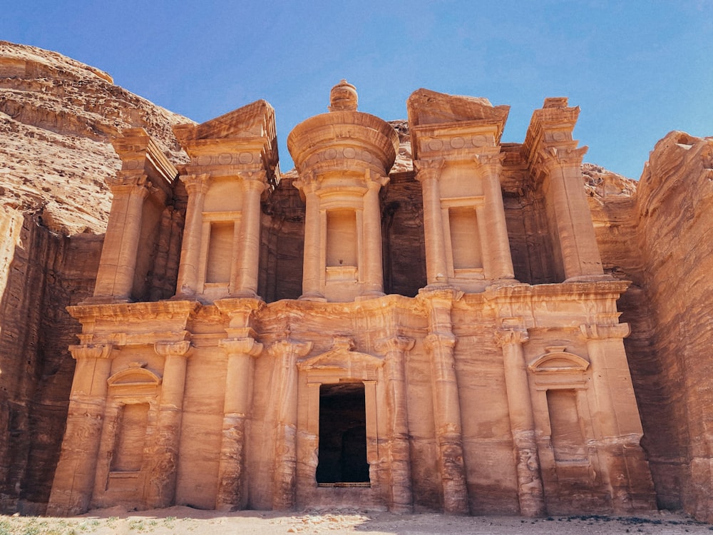 a large ancient building with Petra in the background