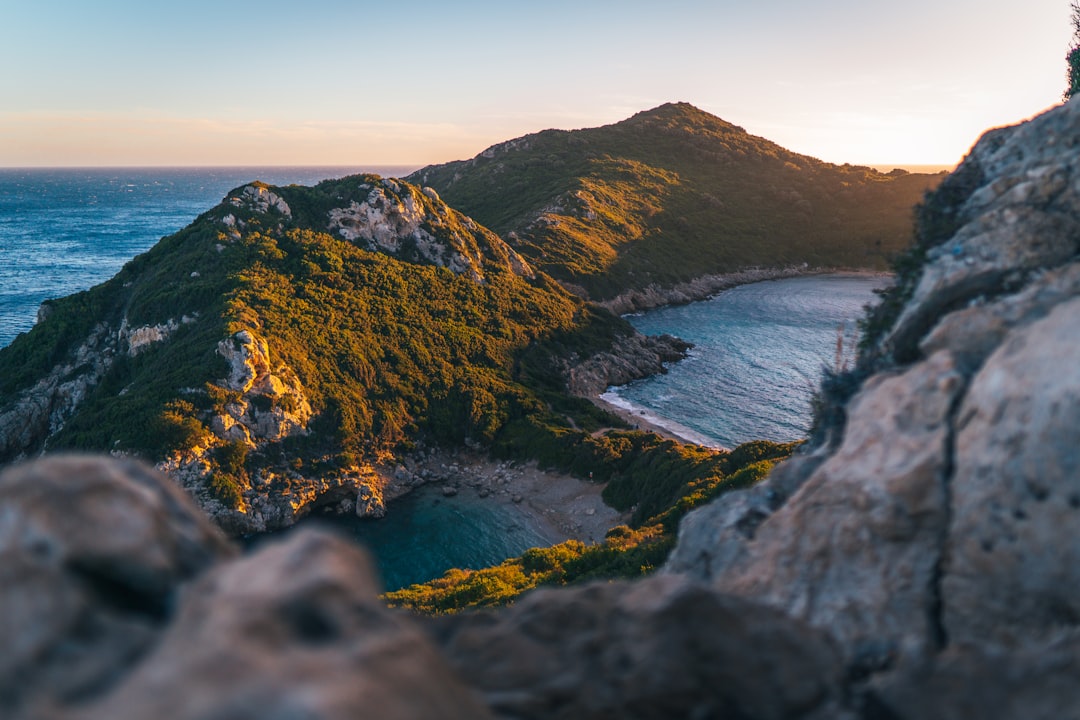 a rocky cliff with a body of water below,