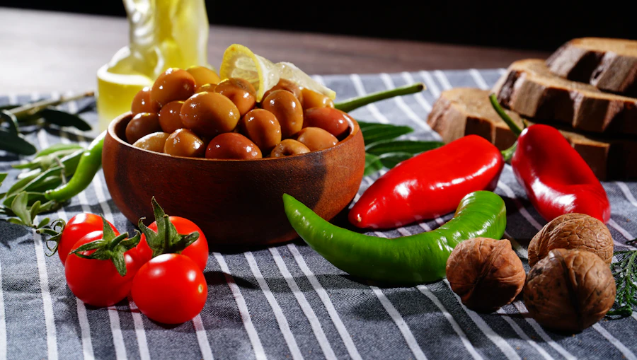 Bol d'olives marinées au citron, huile d'olive, tomates cerises, noix et pain sur un torchon rayé