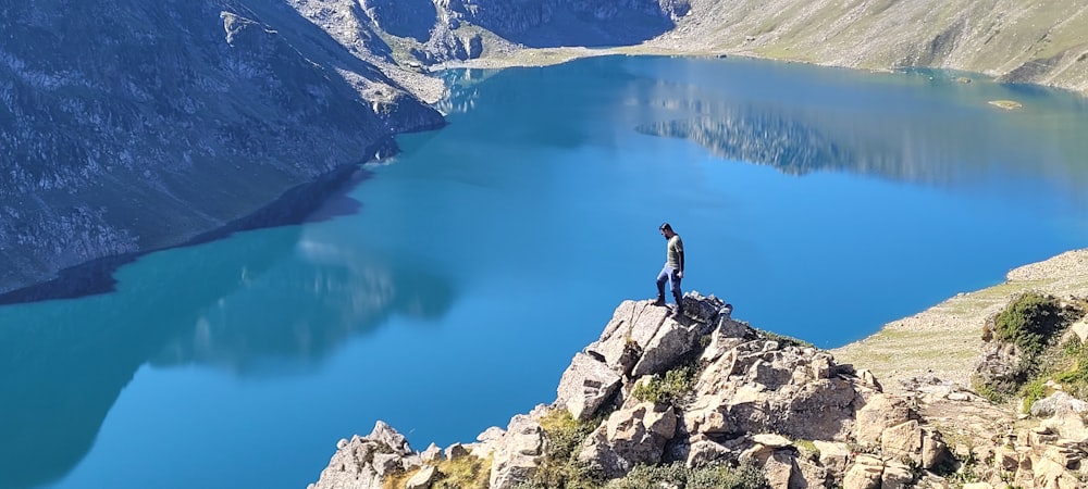 a person standing on a rock overlooking a body of water