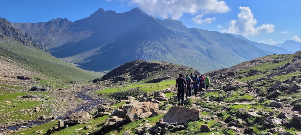 a group of people walking on a mountain