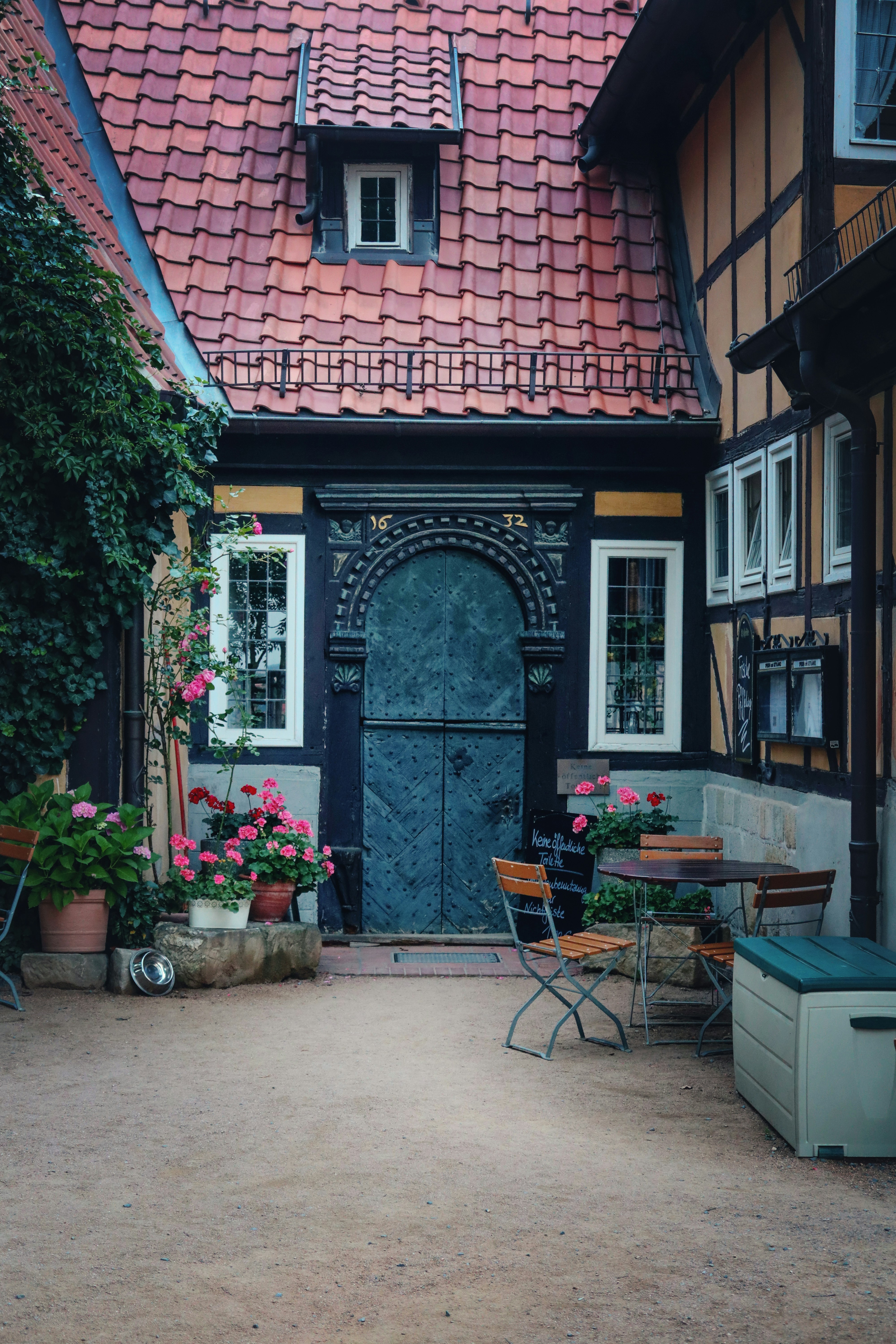 ein Gebäude mit einer lila Tür und einem Tisch und Stühlen draußen