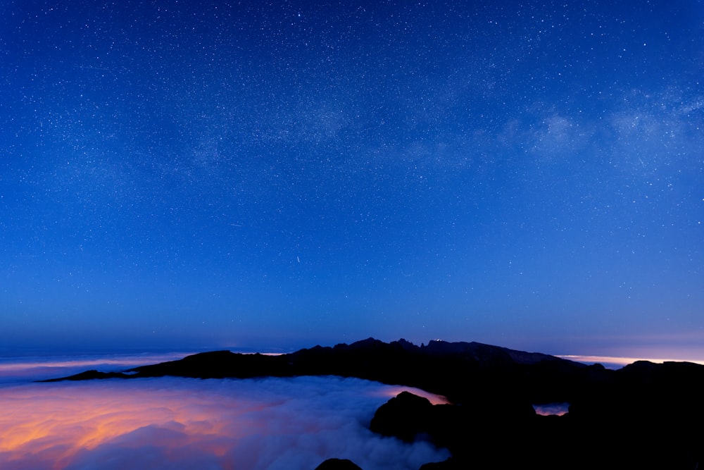 a starry night sky over a mountain range