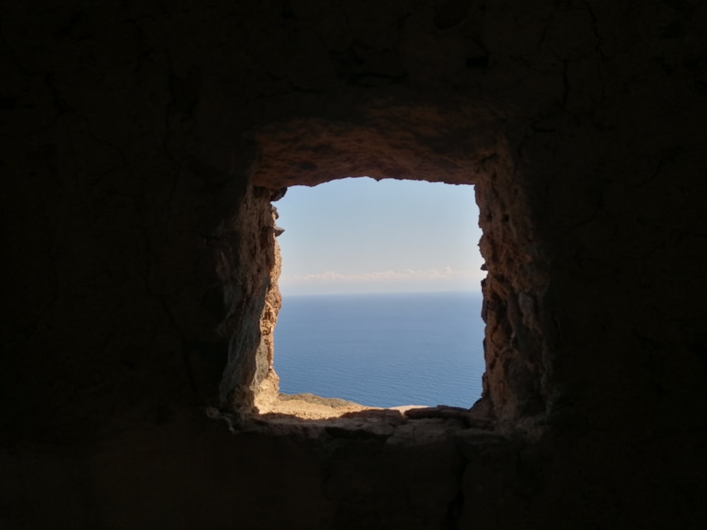 a view of the ocean through a stone archway