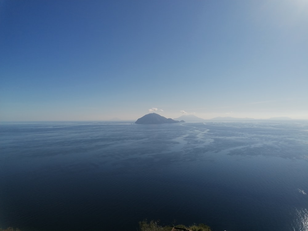 a large body of water with a mountain in the distance