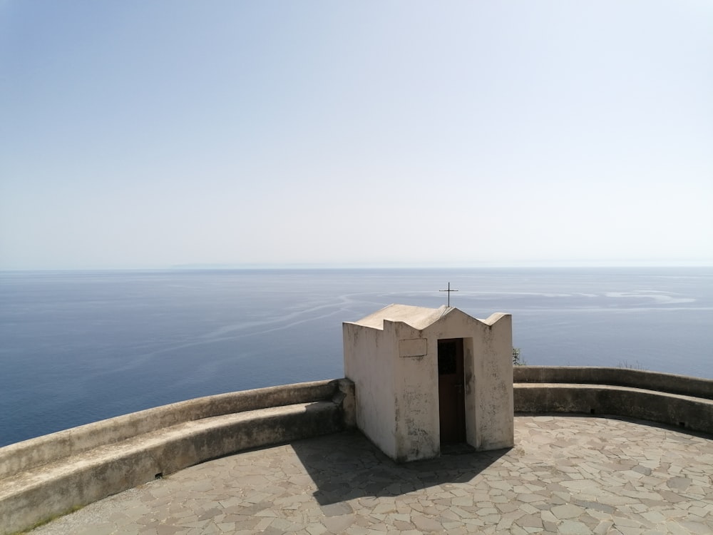 a stone structure on a stone walkway by the ocean