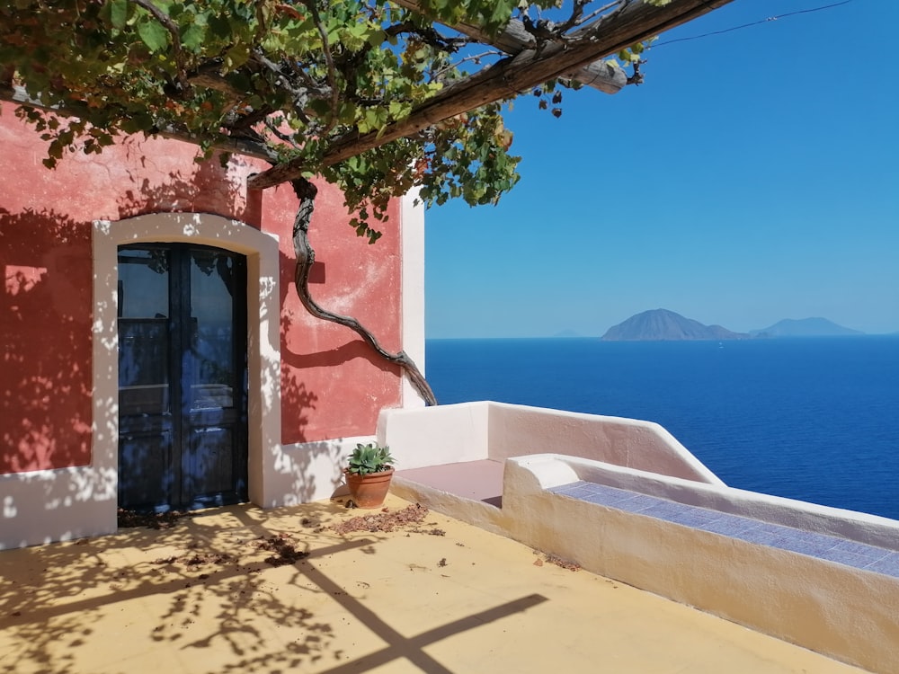 a building with a door and a body of water in the background