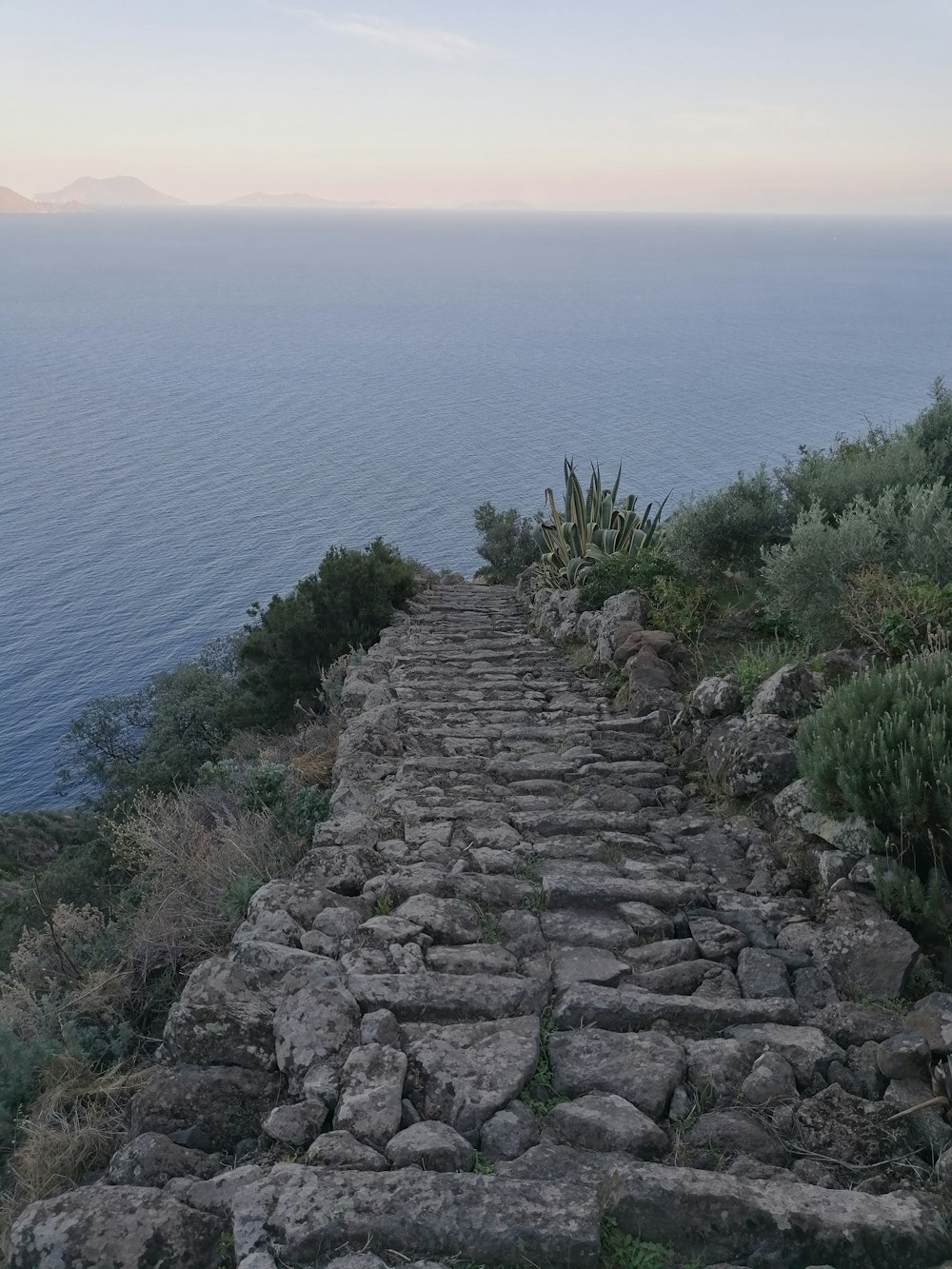 a rocky path leading to a body of water