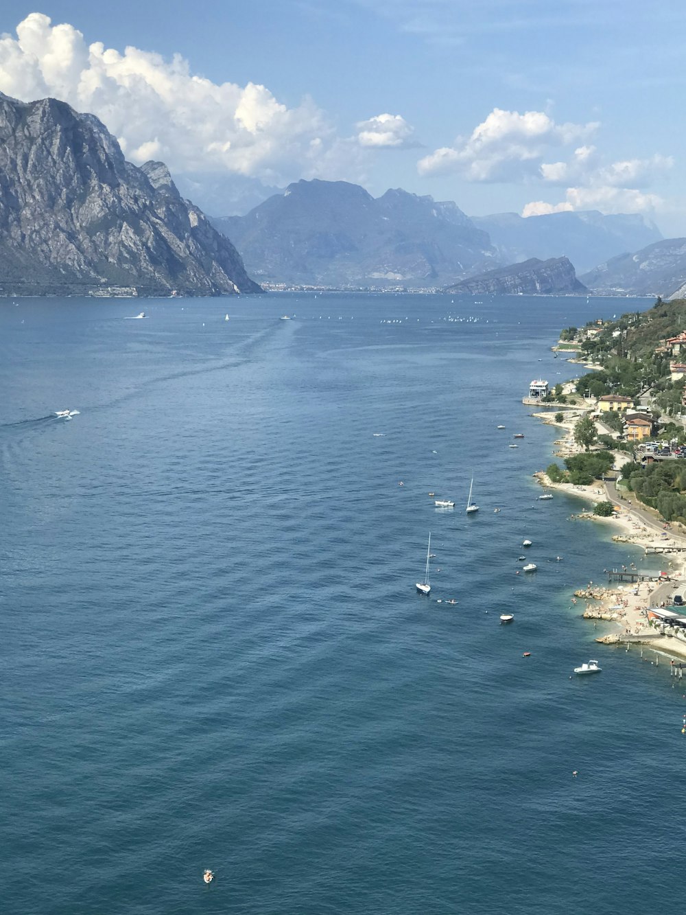 a body of water with boats in it and mountains in the back