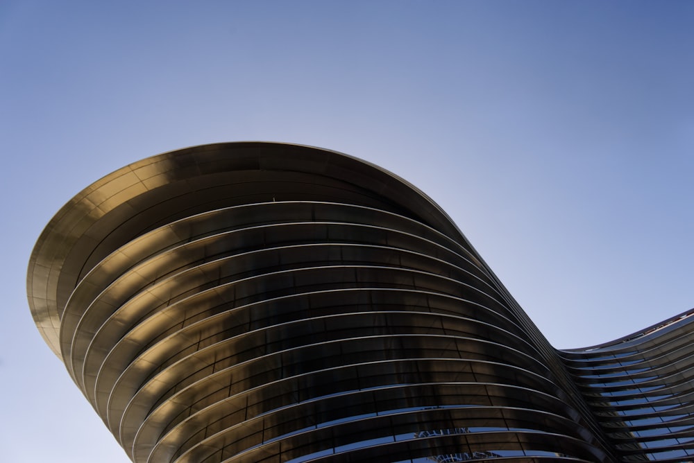 a tall building with a curved top with Aqua in the background