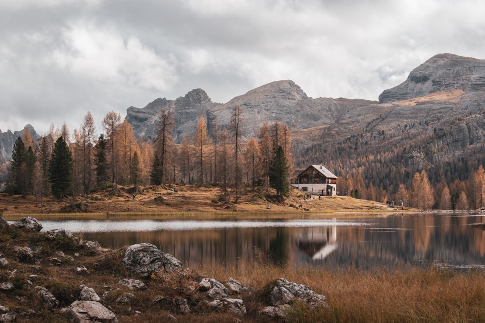 a house by a lake with mountains in the background