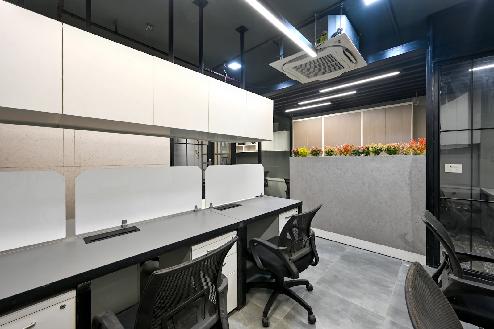 Meeting room with a long table and chairs under industrial pendant lighting