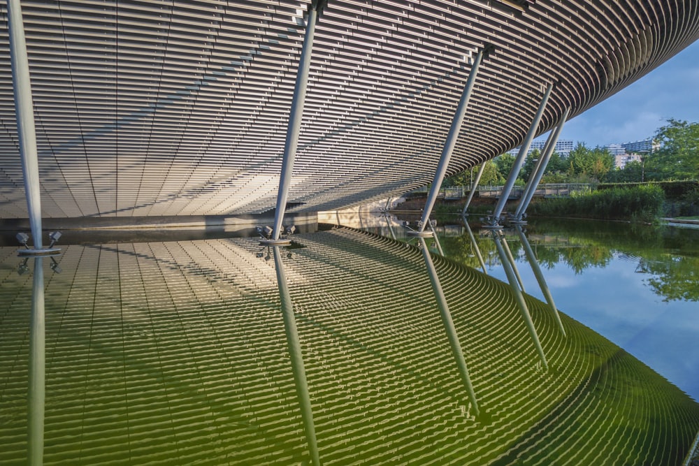 a large greenhouse with a body of water in the background