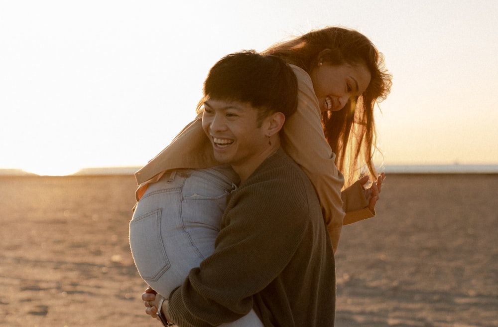 a man and woman hugging on a beach