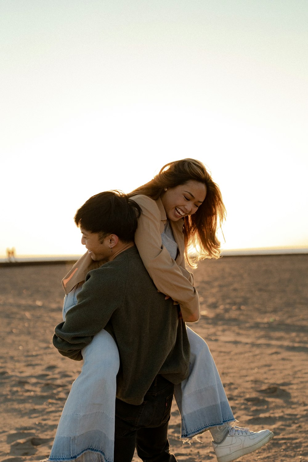 a man and woman hugging on a beach