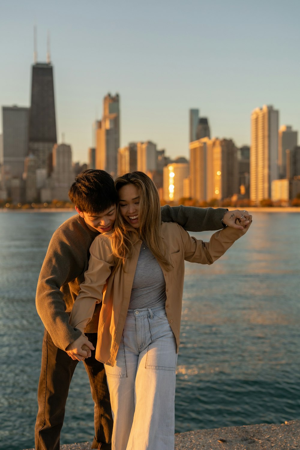 a man and woman posing for a picture with a city in the background