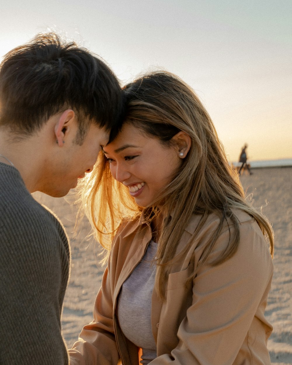 a man and woman kissing on a beach