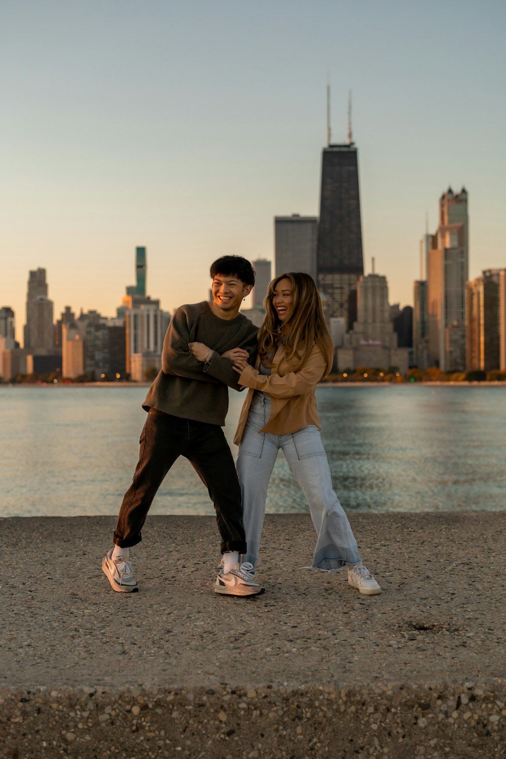 a man and woman posing for a picture with a city in the background