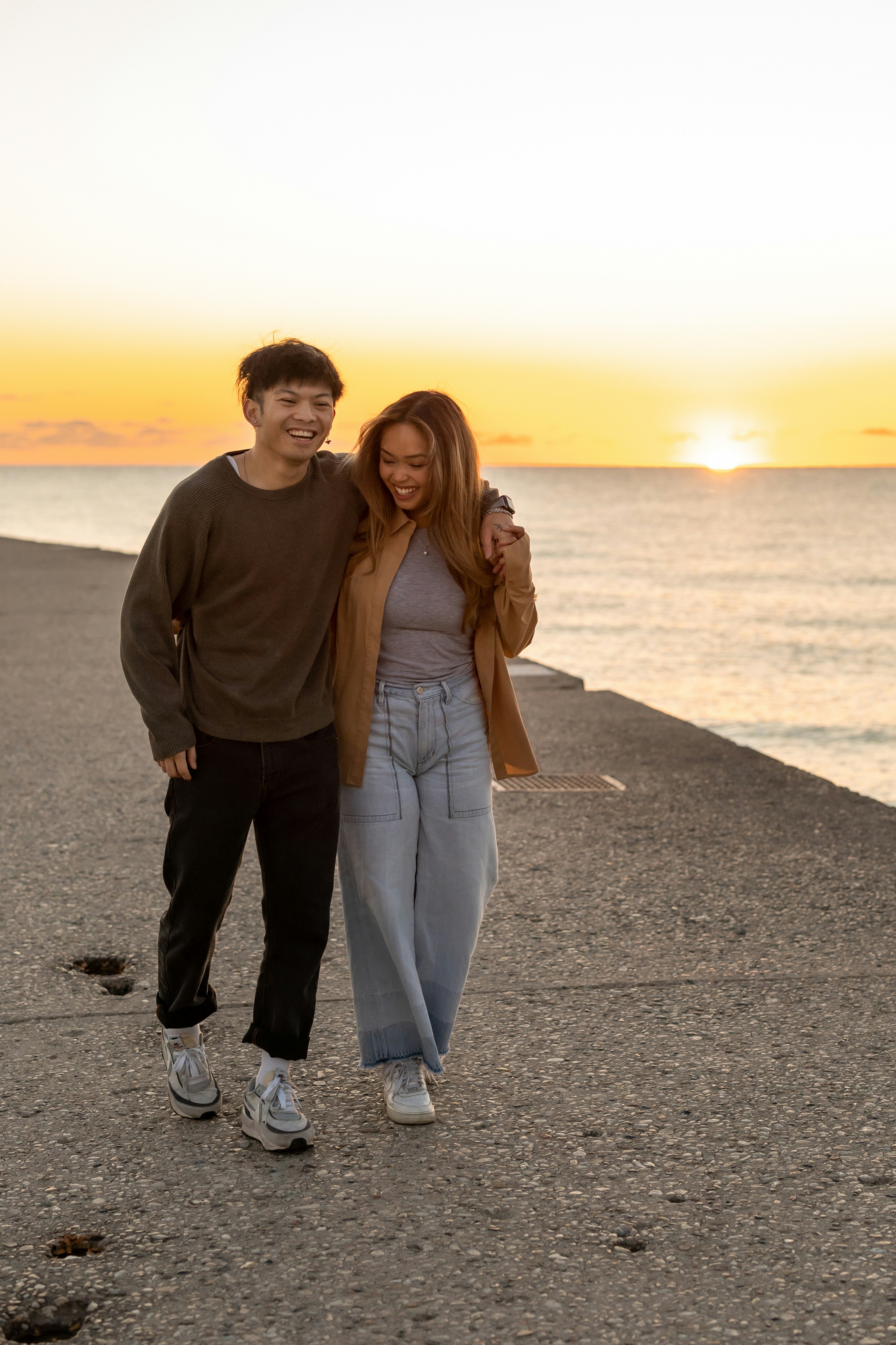 a man and woman posing for a picture on a beach