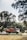 A truck is carrying several gas cylinders, driving along a road bordered by trees. The background is slightly blurred, indicating motion.