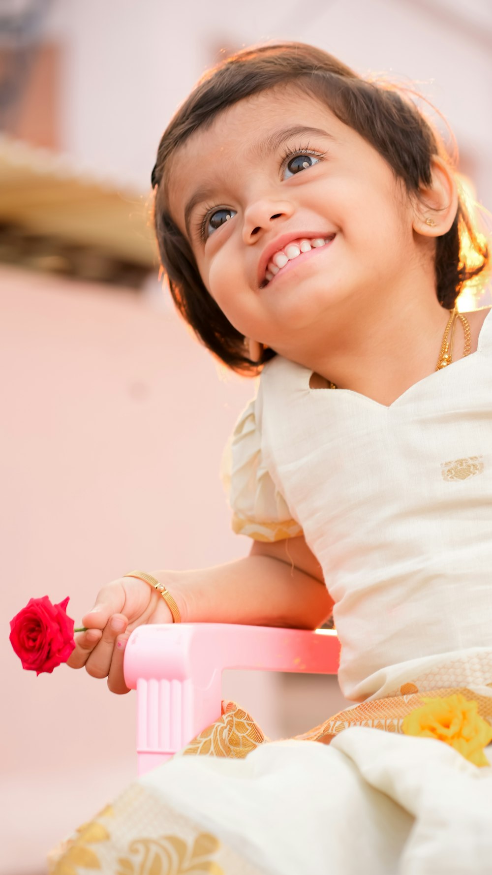 a girl holding a pink rose