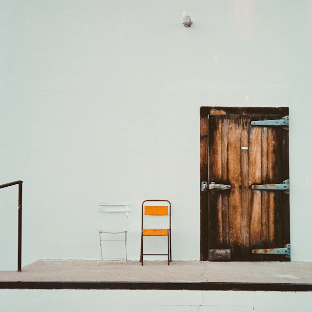 A simple chair placed beside a door