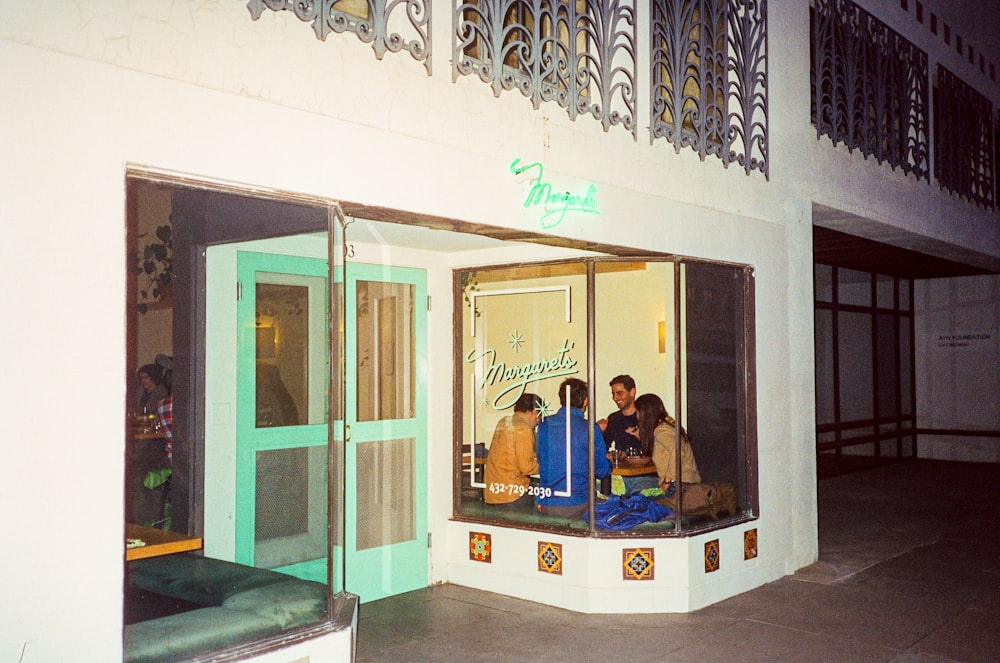 a group of people sitting in a room with a window