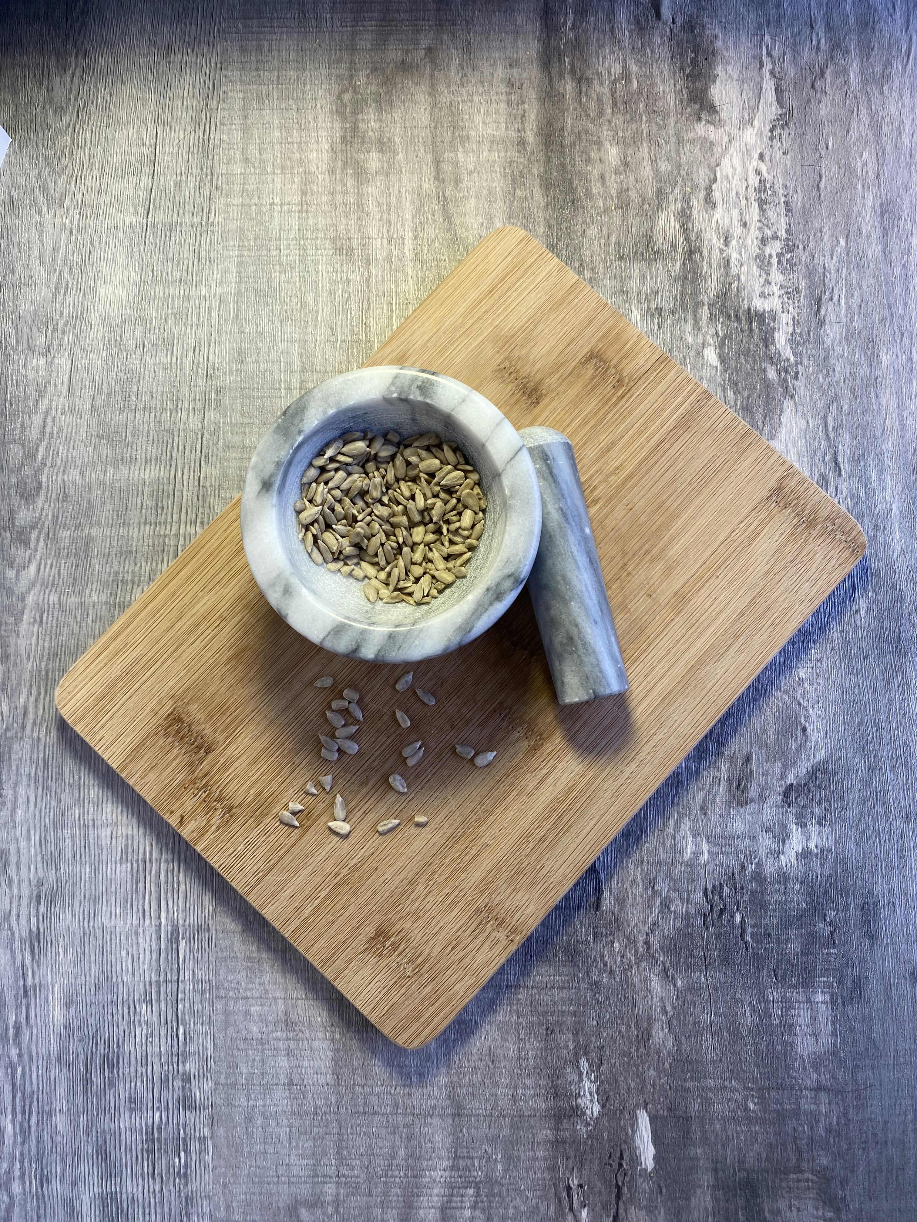 a bowl of seeds on a wooden board