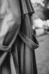 A close-up of a blacksess jacket draped over a chair, highlighting the minimalist luxury fabric texture.