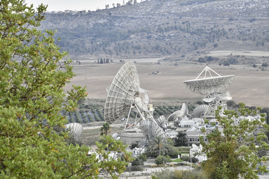 a large white building with a dome roof surrounded by trees, I captured these satellite dishes in a valley.