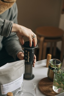 a person holding an AeroPress | KopiFeed.id