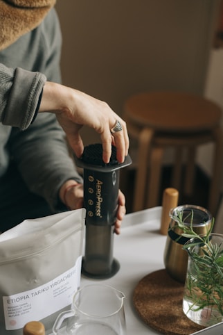 a person holding an AeroPress | KopiFeed.id
