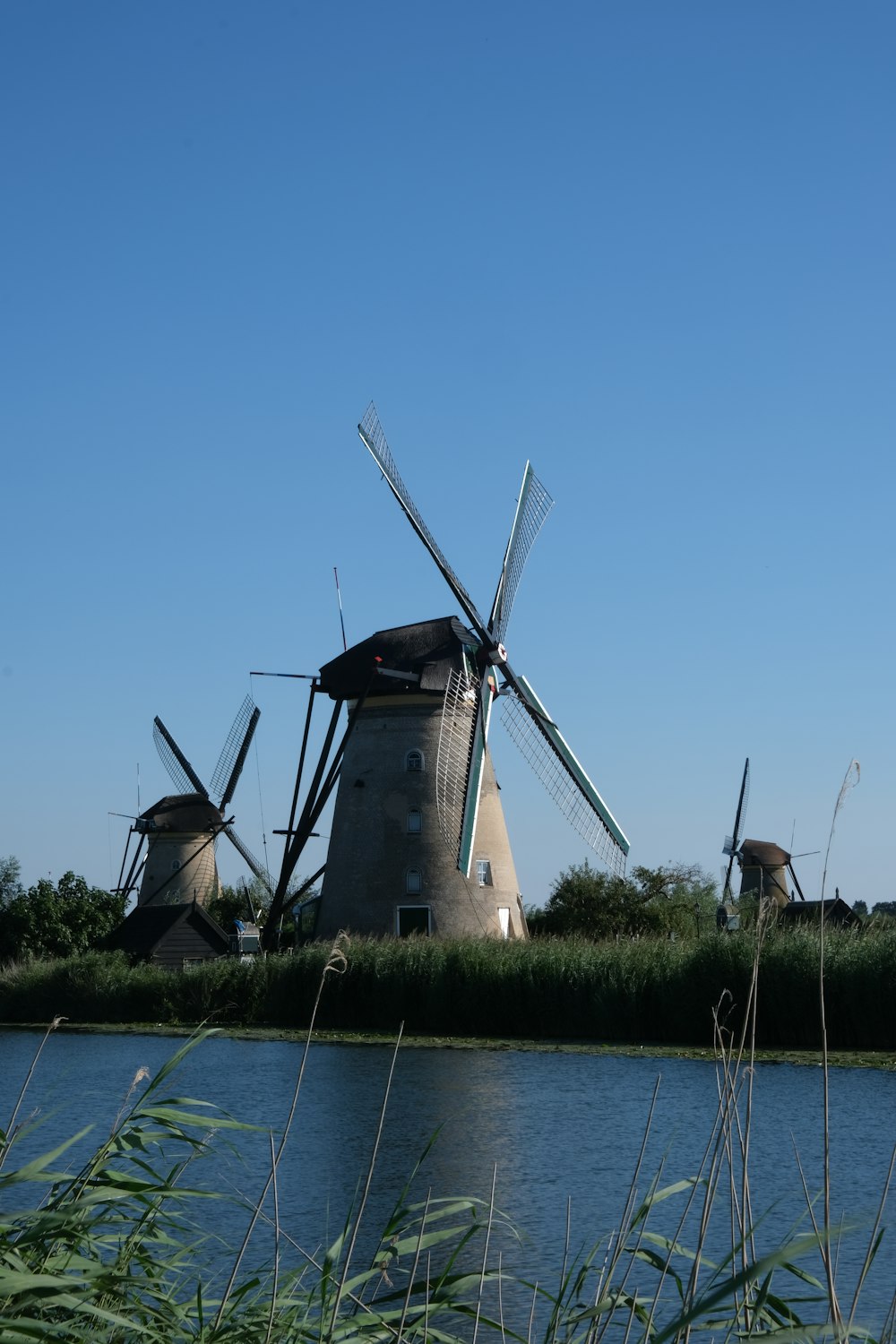 a group of windmills by a body of water