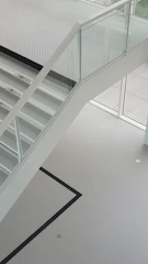 Glass railing on a staircase with a clear view of the living room.