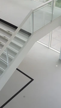 Glass railing on a staircase with a clear view of the living room.