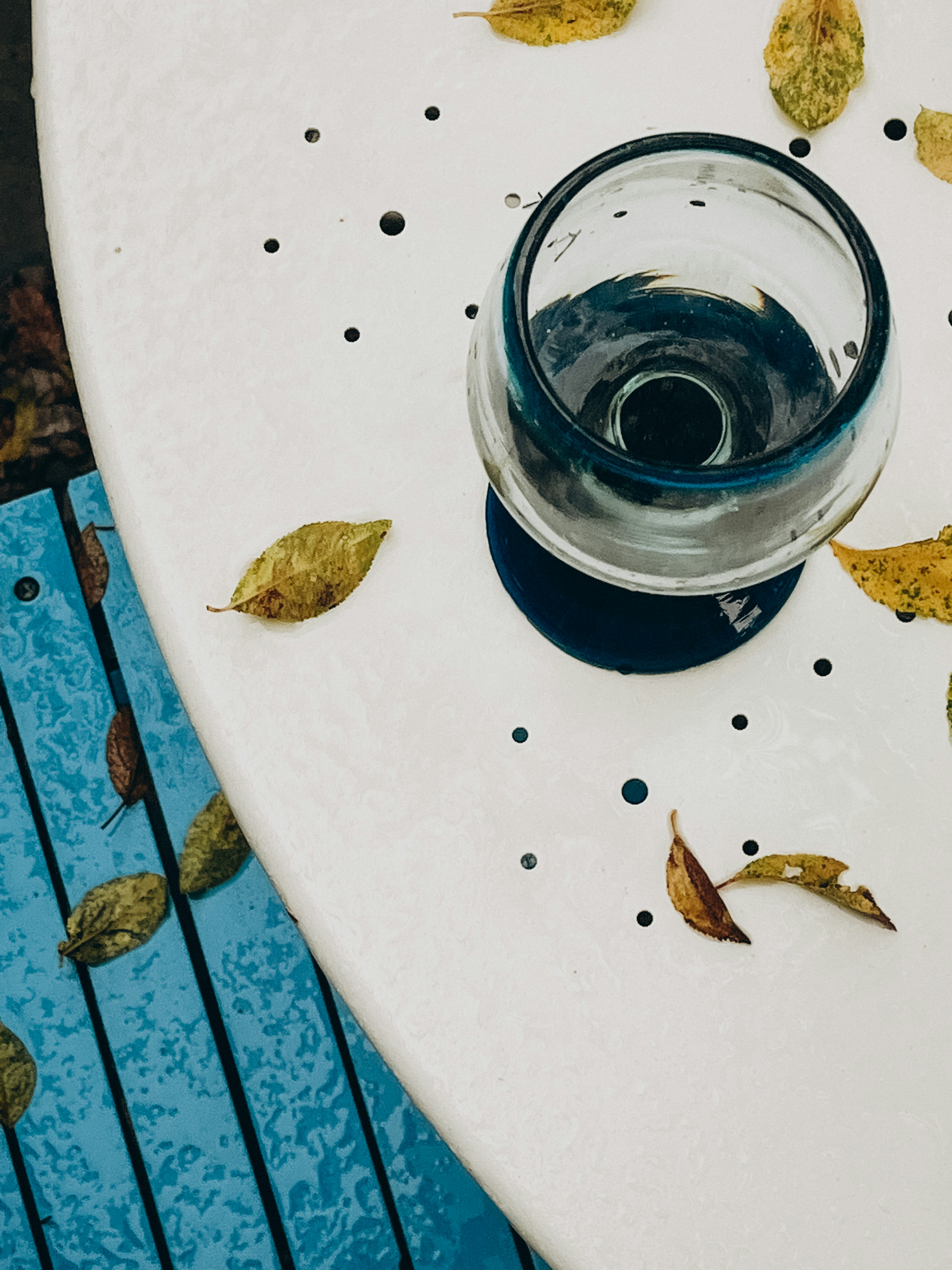 a blue cup with a lid and a group of small brown objects on a white surface