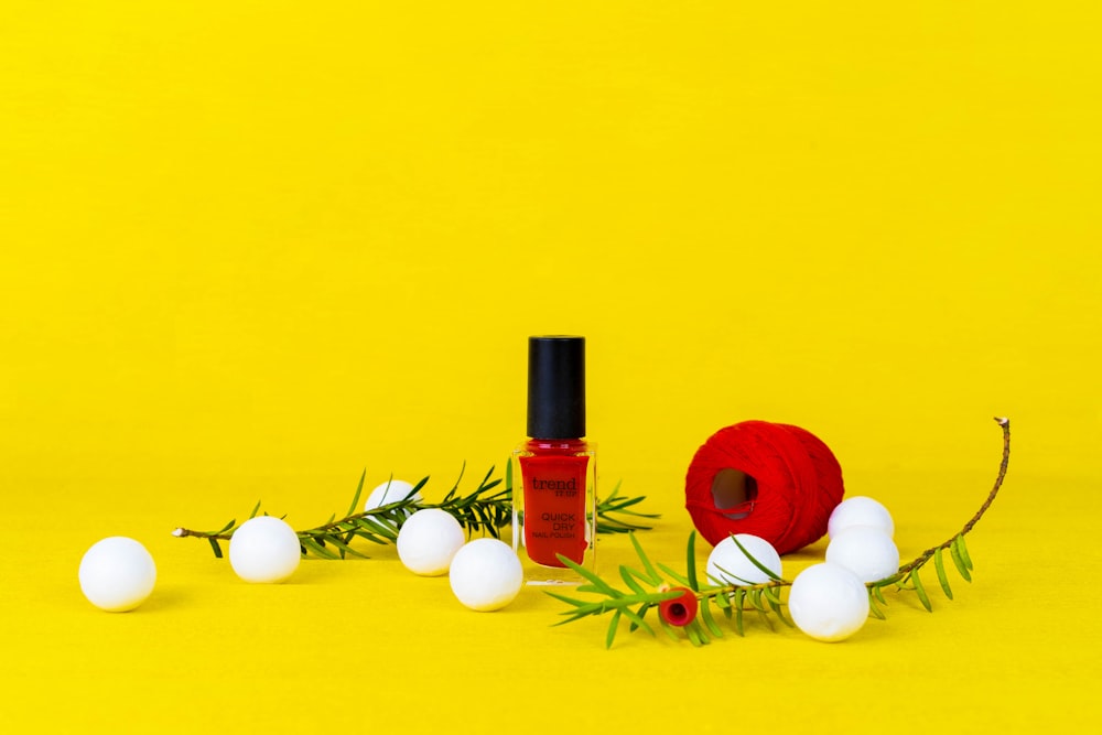 a bottle of red liquid and white eggs on a yellow background