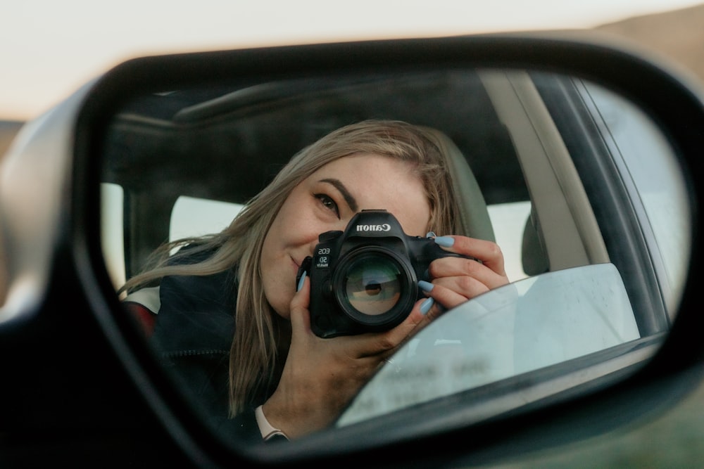 a person holding a camera in a car