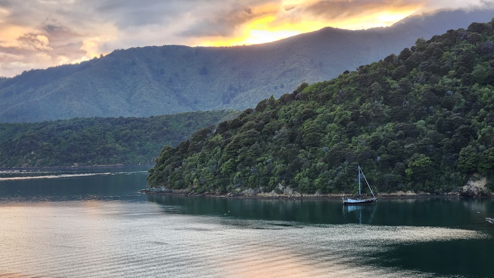 a body of water with a boat in it and a hill in the back