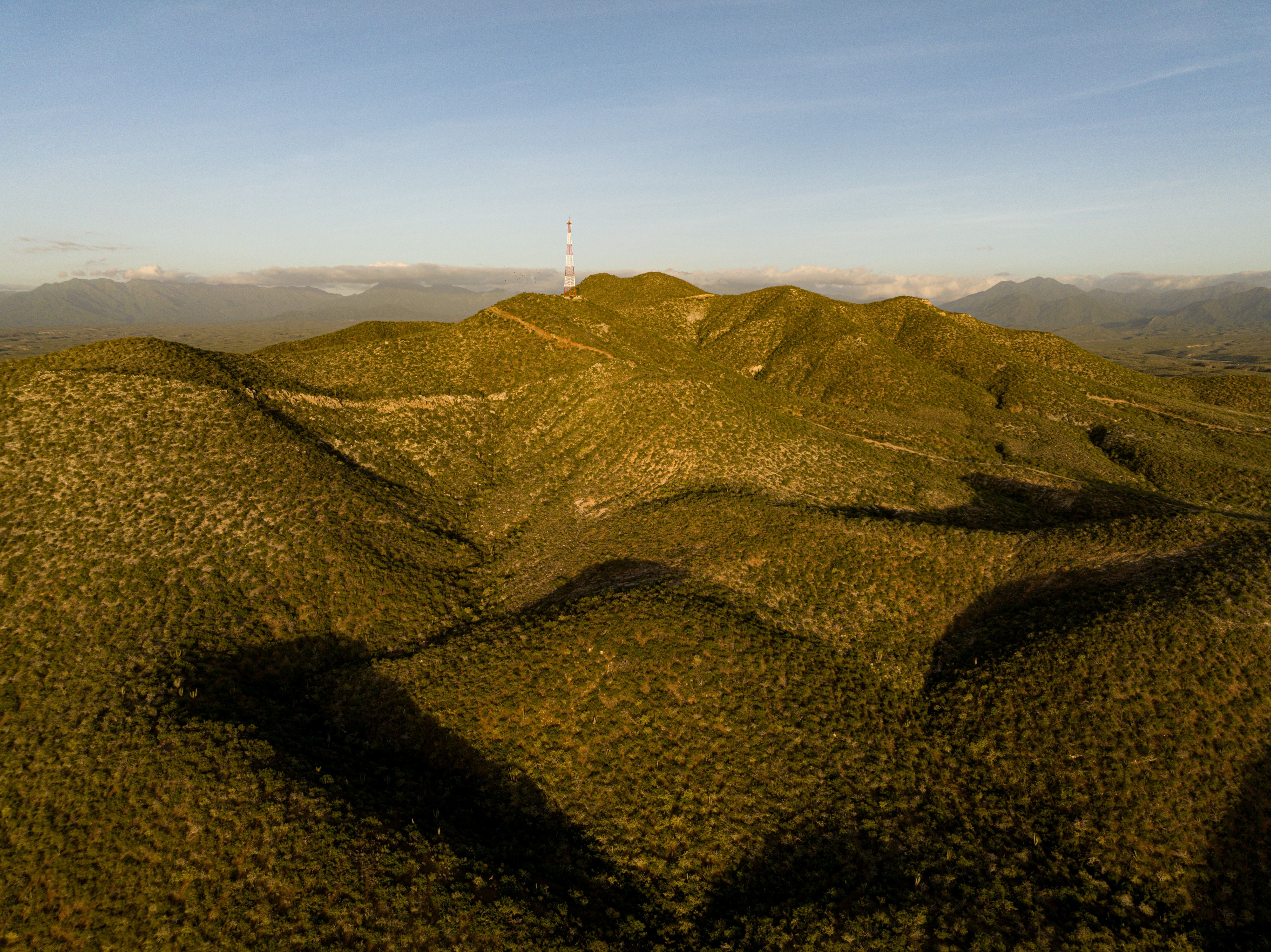 a grassy hill with a white tower