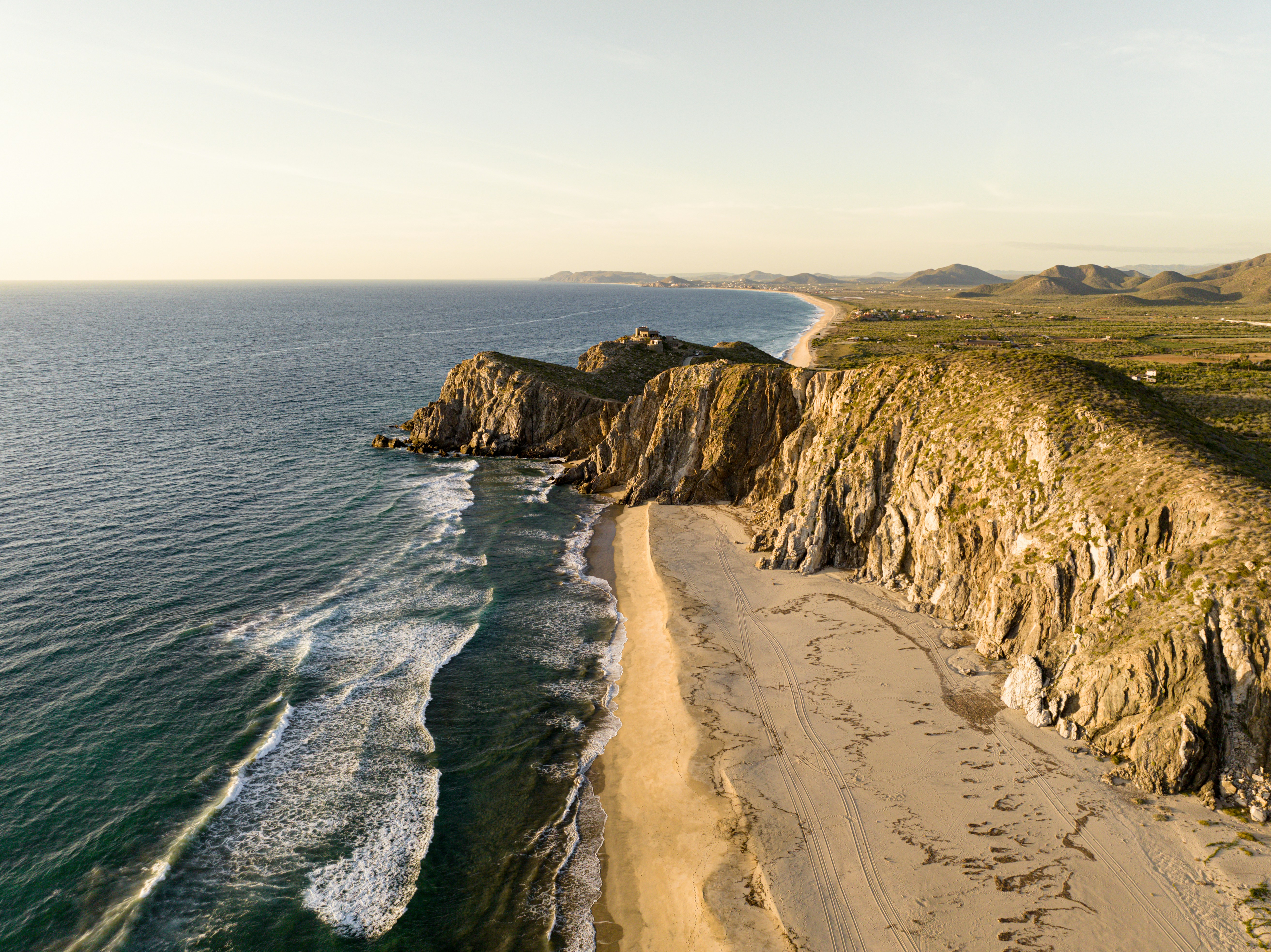 a beach with a cliff and water