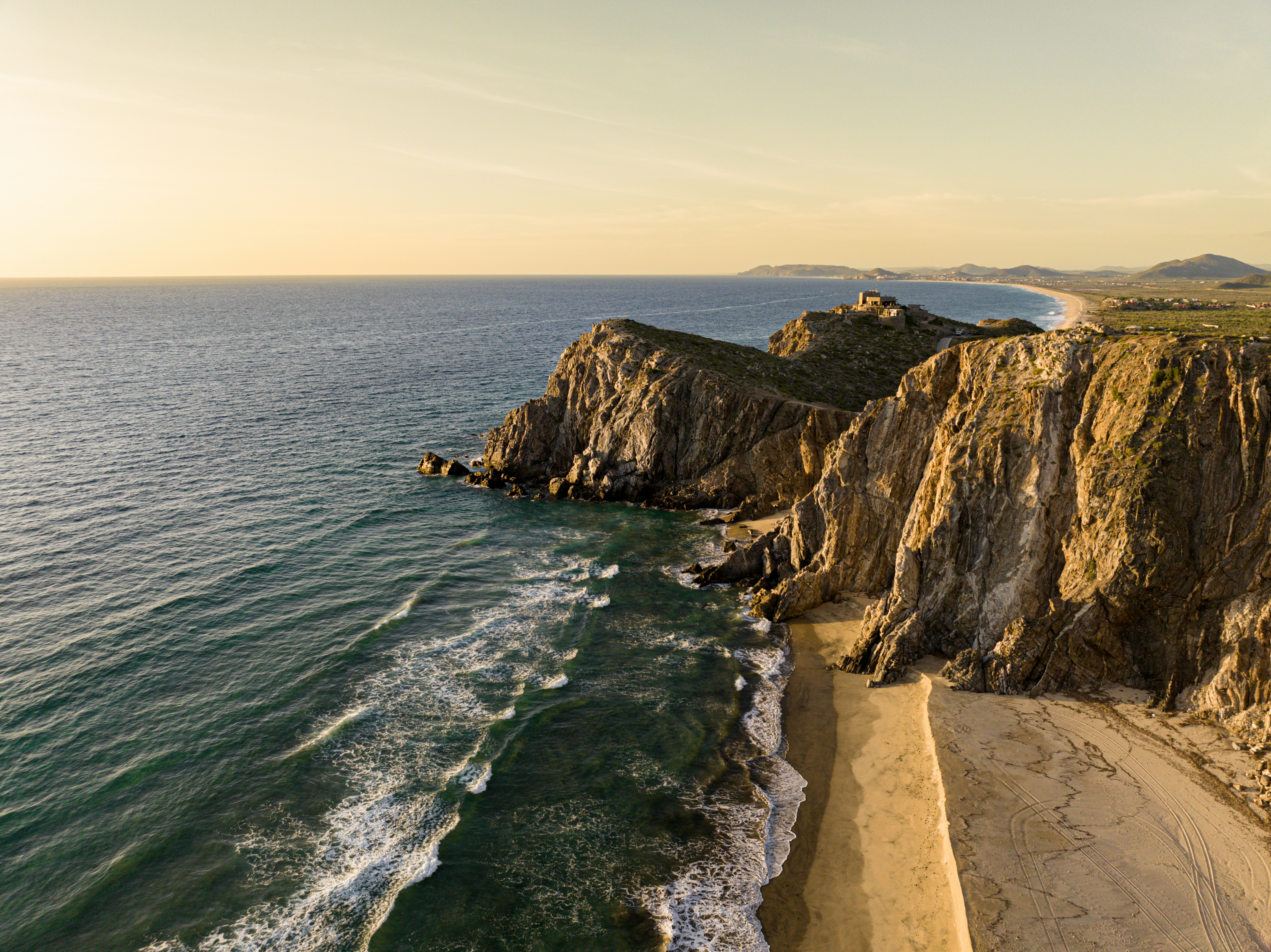 a rocky beach with a body of water and a sandy beach
