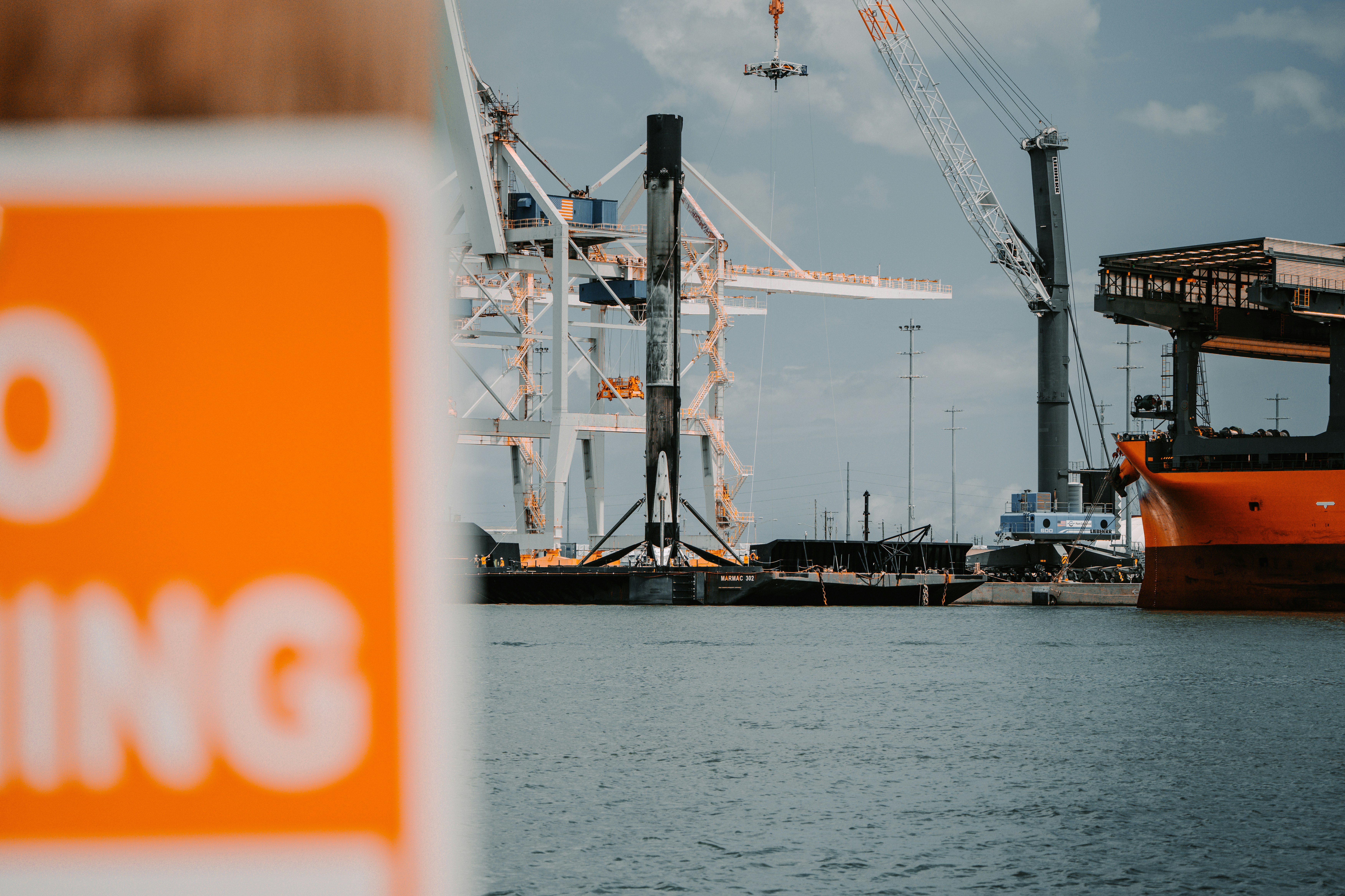 a crane at a port, Booster refurbishing by spacex